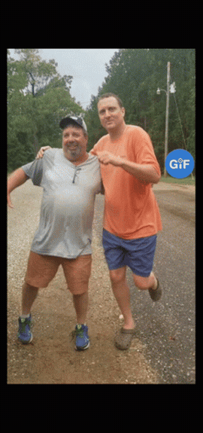 Two Men Standing On Dirt Road GIF