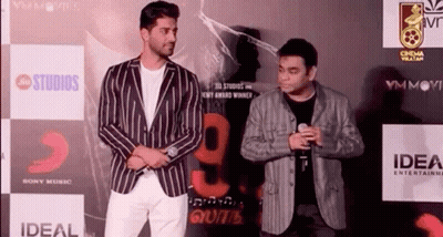 Two Men Standing On Red Carpet GIF