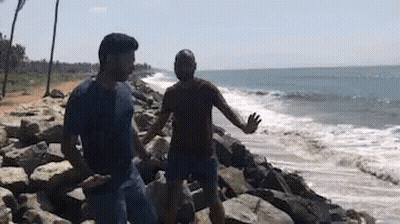 Two Men Standing On Rocky Beach GIF