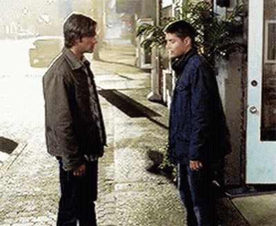 Two Men Standing on Sidewalk in Front of Building