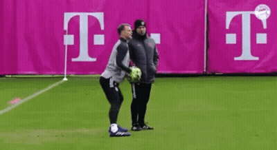 Two Men Standing On Soccer Field Holding Ball GIF