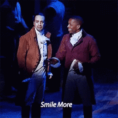 Two Men Standing On Stage Saying Smile More GIF