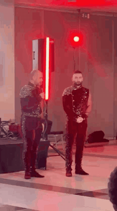 Two Men Standing On Stage With Red Light GIF