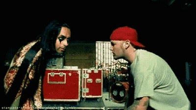 Two Men Standing One In Green Shirt And Red Hat GIF