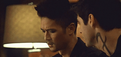 Two Men Standing, One With Neck Tattoo Saying X GIF