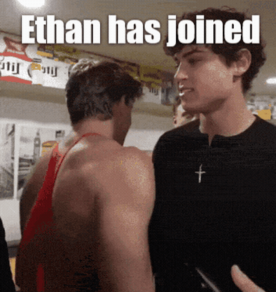 Two Men Standing With Ethan Has Joined Caption GIF