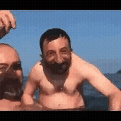 Two Men Swimming Shirtless In Ocean GIF