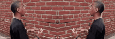 Two Men Talking Beside Red Brick Wall GIF