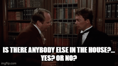 Two Men Talking In Front Of Bookshelf GIF