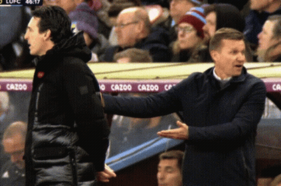 Two Men Talking In Front Of Cazoo Banner GIF
