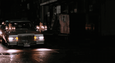 Two Men Talking In Front Of Dario M Sign GIF
