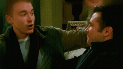 Two Men Talking In Front Of Framed Picture GIF