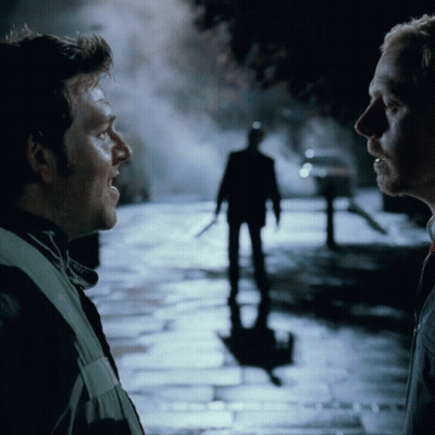 Two Men Talking In Front Of Man Silhouette GIF