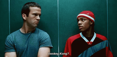 Two Men Talking Next To Green Wall GIF