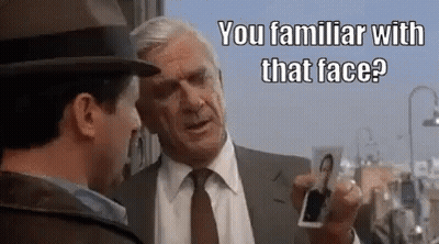 Two Men Talking One Holding Picture Of Man GIF
