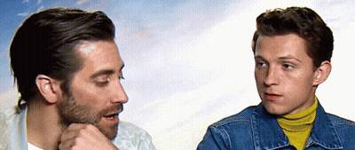 Two Men Talking One In Denim Jacket And Yellow Turtleneck GIF