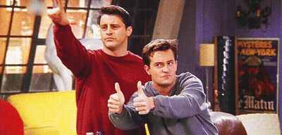 Two Men Thumbs Up In Front Of Mysteries New York Poster GIF