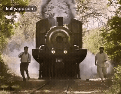 Two Men Walking In Front Of A Train GIF