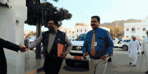 Two Men Walking In Front Of Toyota SGV GIF