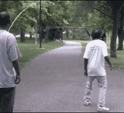 Two Men Walking In Park One Wearing White Shirt Saying A GIF