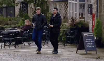 Two Men Walking Next To Breakfast Sign GIF