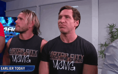 Two Men Wearing Black Motor City Machine Guns Shirts GIF