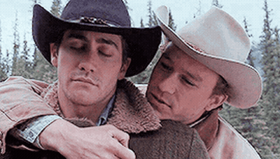 Two Men Wearing Cowboy Hats Are Hugging Each Other In A Forest . GIF