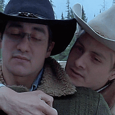 Two Men Wearing Cowboy Hats Are Hugging Each Other With Their Eyes Closed GIF