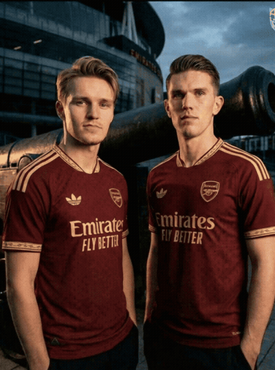 Two Men Wearing Emirates Fly Better Shirts Pose For A Picture GIF