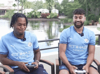 Two Men Wearing Etihad Airways Shirts Sit In Chairs GIF