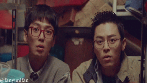 Two Men Wearing Glasses Are Standing Next To Each Other In A Room With The Words Fanyunifan Below Them GIF