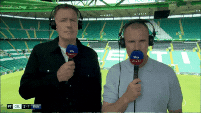 Two Men Wearing Headphones And Holding Microphones In Front Of A Stadium That Says ' Sky Sports ' On It GIF