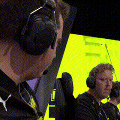 Two Men Wearing Headphones Are Sitting In Front Of A Yellow Screen . GIF