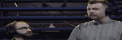 Two Men Wearing Headphones Are Standing Next To Each Other In A Stadium GIF