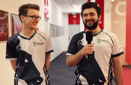 Two Men Wearing Monster Energy Shirts Are Standing Next To Each Other In A Hallway GIF