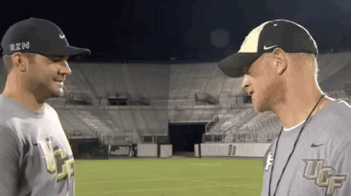 Two Men Wearing Nike Hats And Shirts With Ucf On Them GIF