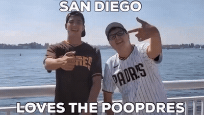 Two Men Wearing Padres Jerseys Are Standing Next To Each Other On A Bridge . GIF