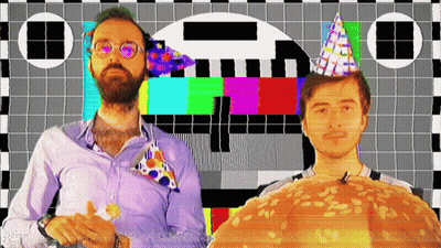 Two Men Wearing Party Hats Are Standing In Front Of A Checkered Screen GIF
