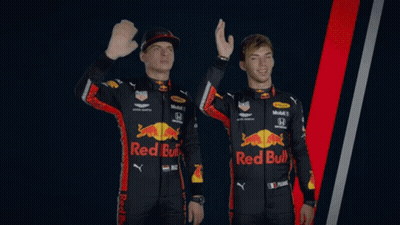 Two Men Wearing Red Bull Racing Uniforms Are Waving GIF