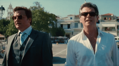 Two Men Wearing Suits And Sunglasses Are Standing Next To Each Other GIF