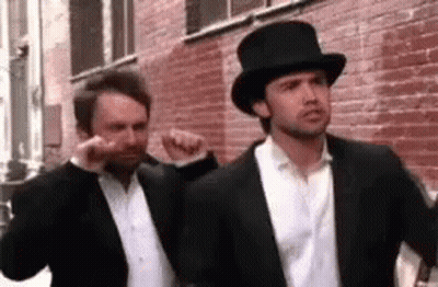 Two Men Wearing Suits And Top Hats Are Standing Next To Each Other . GIF
