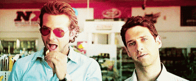 Two Men Wearing Sunglasses Are Standing Next To Each Other In Front Of A Store That Says N7 GIF