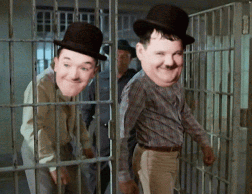 Two Men Wearing Top Hats Are Behind Bars GIF