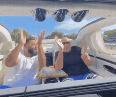 Two Men With Arms Up In Boat GIF