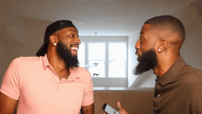Two Men With Beards Are Laughing And One Is Holding A Cell Phone In His Hand GIF