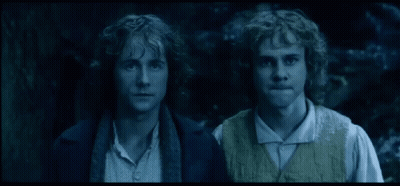 Two Men With Curly Hair Standing In The Dark GIF