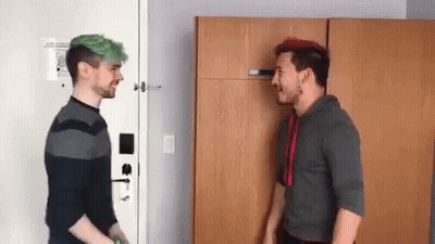 Two Men With Green Hair Are Standing Next To Each Other In A Room And Talking To Each Other . GIF
