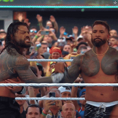 Two Men Wrestling In Front Of A Crowd With A Star On The Bottom Right GIF
