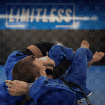 Two Men Wrestling In Front Of Limitless Sign GIF