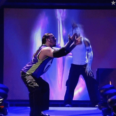 Two Men Wrestling In Front Of Screen With Star GIF